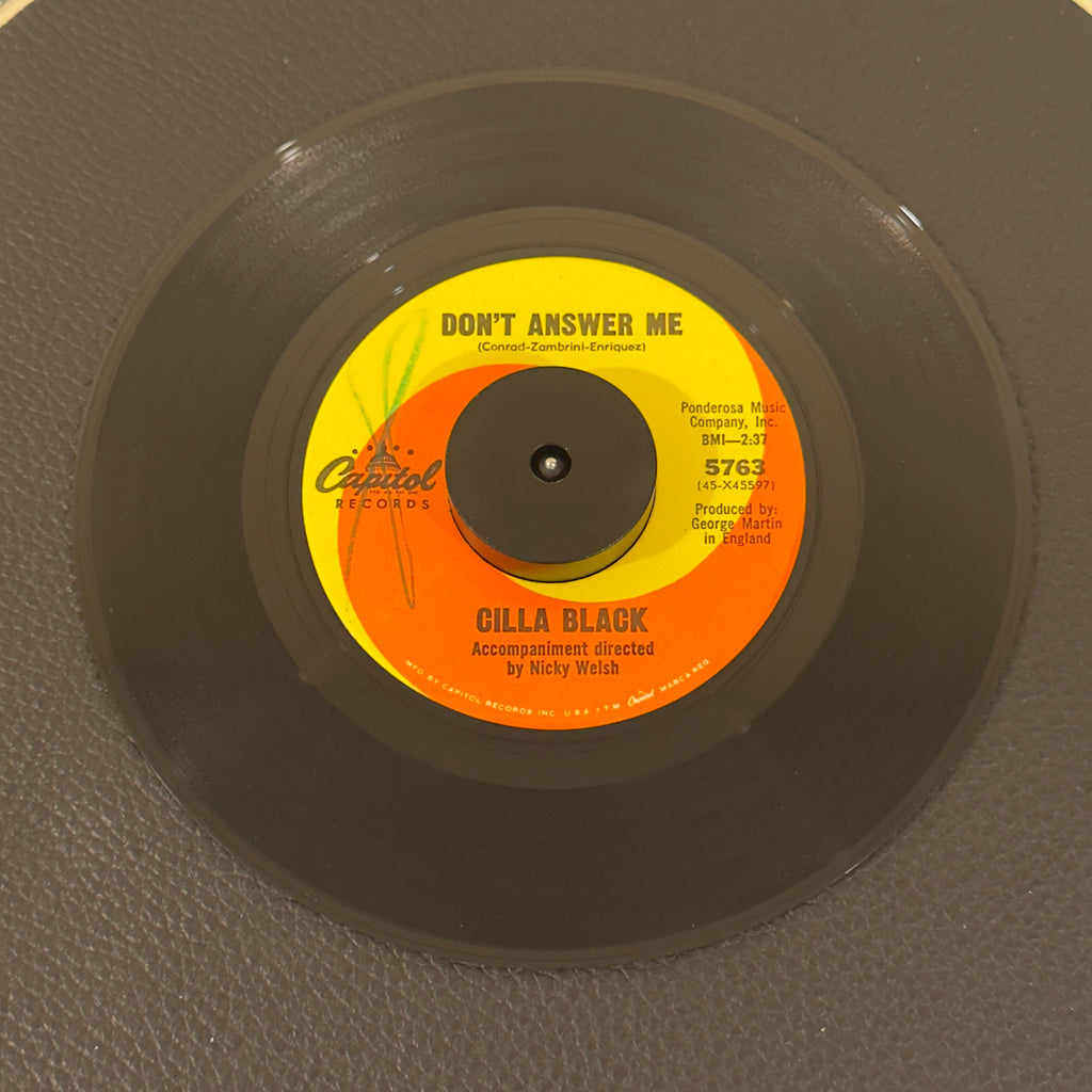 7" vinyl record by Black, Cilla featuring "Don't Answer Me/The Right One Is Left", released on Capitol Records (5763), in VG+ (Very Good Plus) condition, classic analog collectable for turntable playback. Includes original Capitol Records sleeve.  Writing on Side A of label.