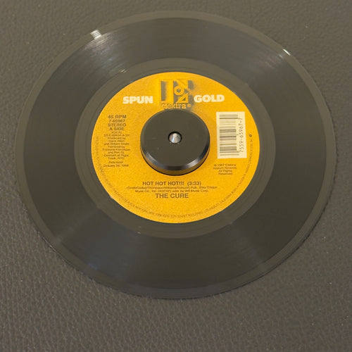 7" vinyl record by Cure, The featuring "Hot Hot Hot!!! (Remix)/Why Can't I Be You?", released on Elektra Spun Gold (7-65967), in VG+ (Very Good Plus) condition, classic analog collectable for turntable playback. Two back-to-back mega-hits from The Cure’s multi-platinum masterpiece Kiss Me, Kiss Me, Kiss Me. Spun Gold Series.