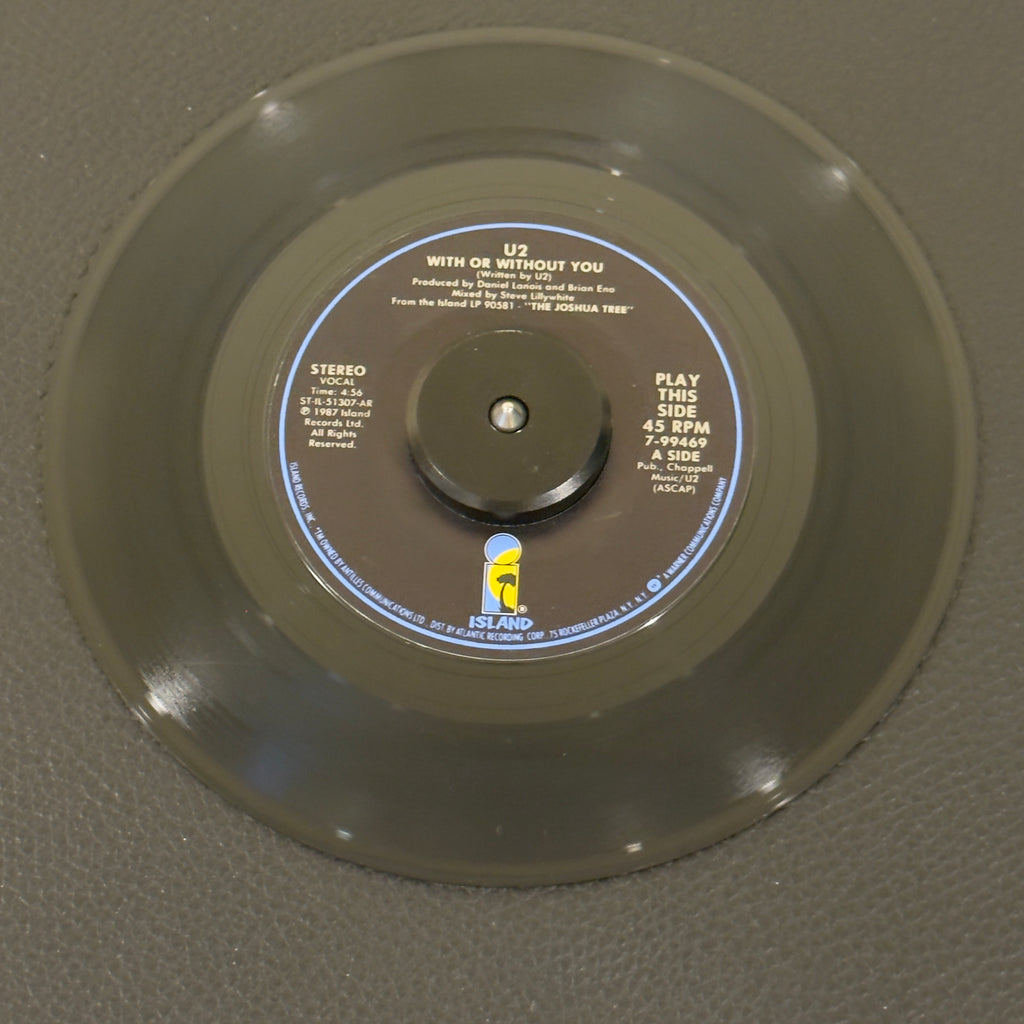 7" vinyl record by U2 featuring "With Or Without You/Luminous Times (Hold On To Love) / Walk To The Water", released on Island Records (7-99469), in VG+ (Very Good Plus) condition, classic analog collectable for turntable playback. Side A: 45 RPM / Side B: 33 1/3 RPM.  Island Records Sleeve.