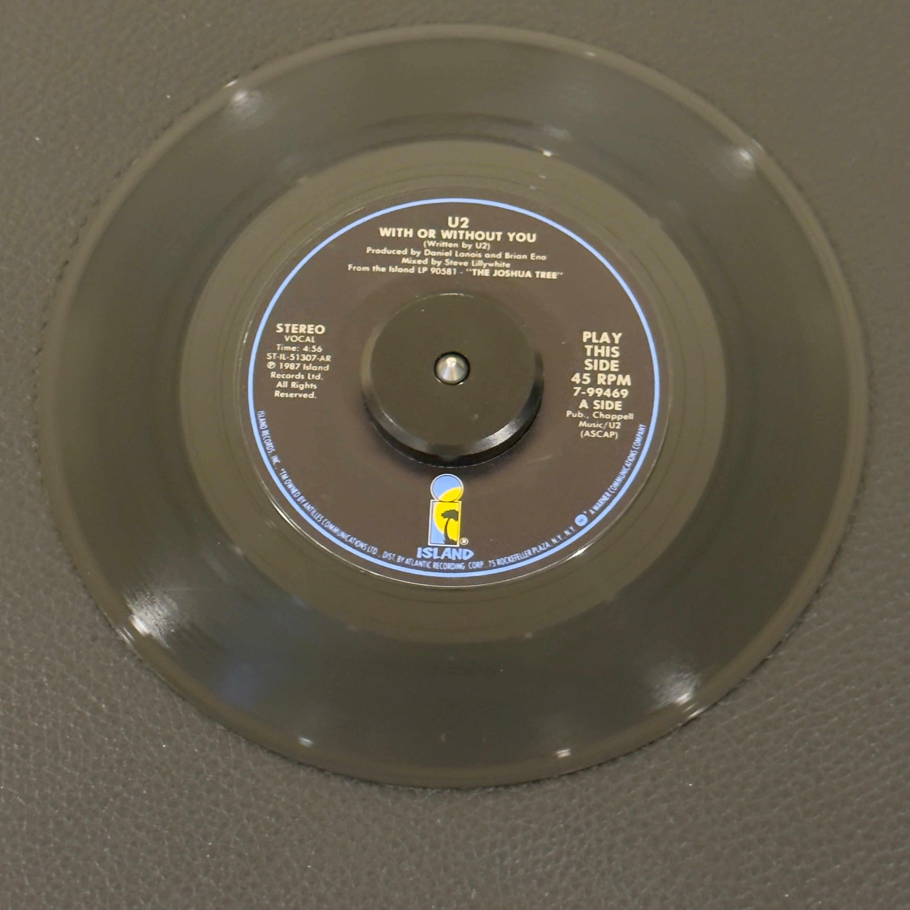 7" vinyl record by U2 featuring "With Or Without You/Luminous Times (Hold On To Love) / Walk To The Water", released on Island Records (7-99469), in VG+ (Very Good Plus) condition, classic analog collectable for turntable playback. Side A: 45 RPM / Side B: 33 1/3 RPM.  Island Records Sleeve.