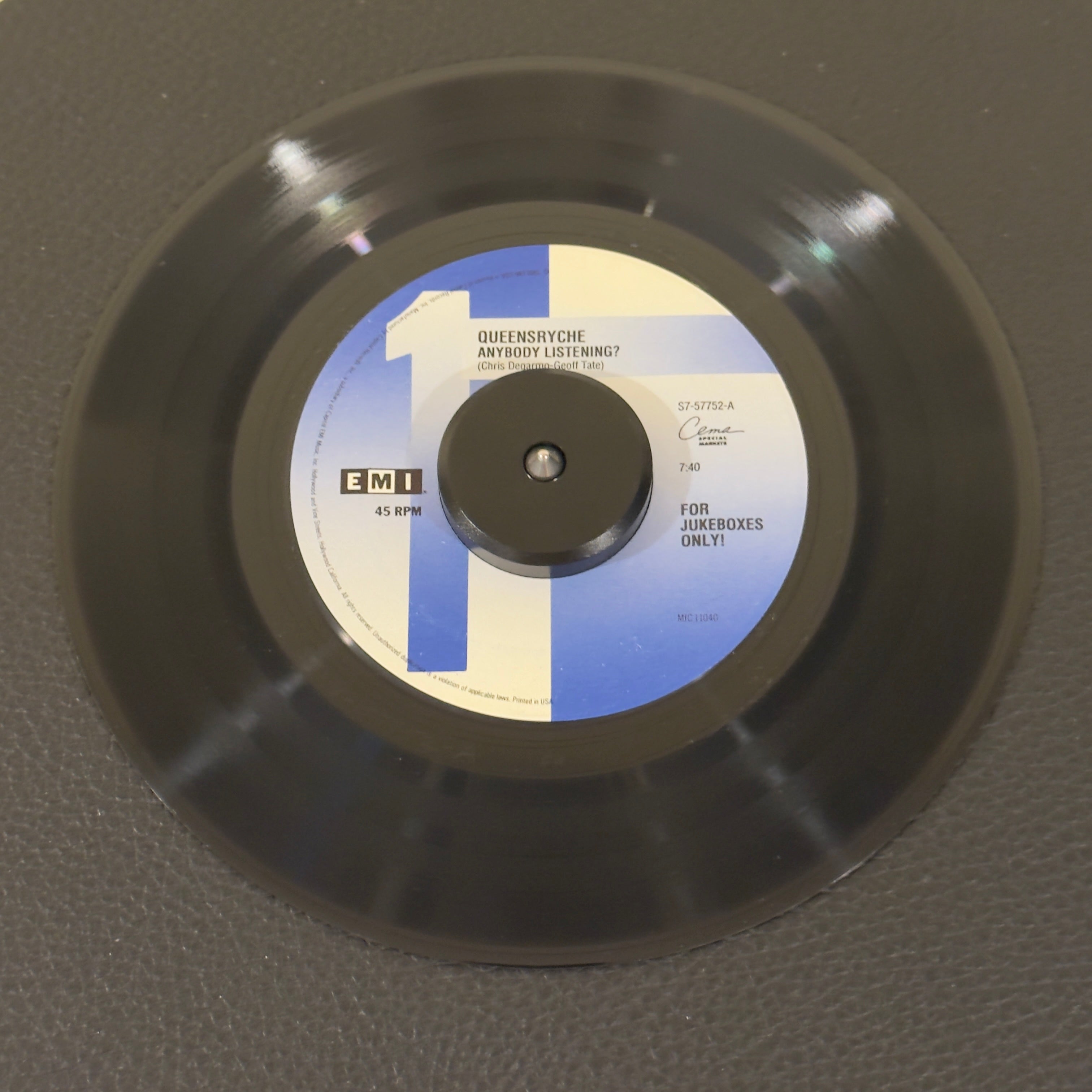7" vinyl record by Queensryche featuring "Anybody Listening?/Silent Lucidity", released on EMI USA (S7-57752), in VG+ (Very Good Plus) condition, classic analog collectable for turntable playback. Scarce 1992 pressing of Queensrÿche's power-ballad masterpiece exclusively for jukebox distribution. Original EMI sleeve included.