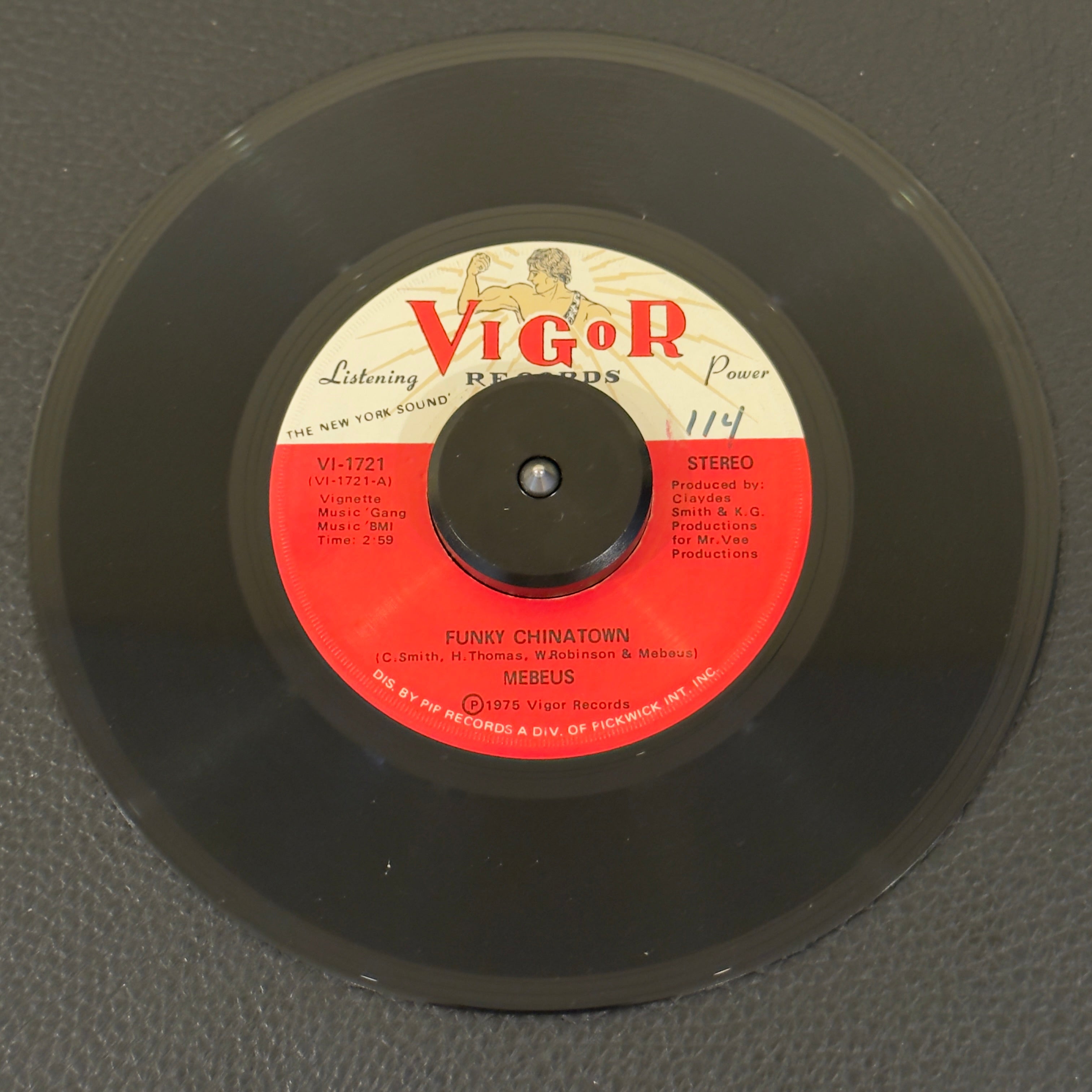 7" vinyl record by Mebeus featuring "Funky Chinatown/Jackie", released on Vigor Records (VI-1721), in NM (Near Mint) condition, classic analog collectable for turntable playback. This rare, 1975 underground synth-and-horn-driven dancefloor mover encapsulates the raw, driving energy of East Coast disco-funk.  Vinyl is NM with writing on both sides of the label.