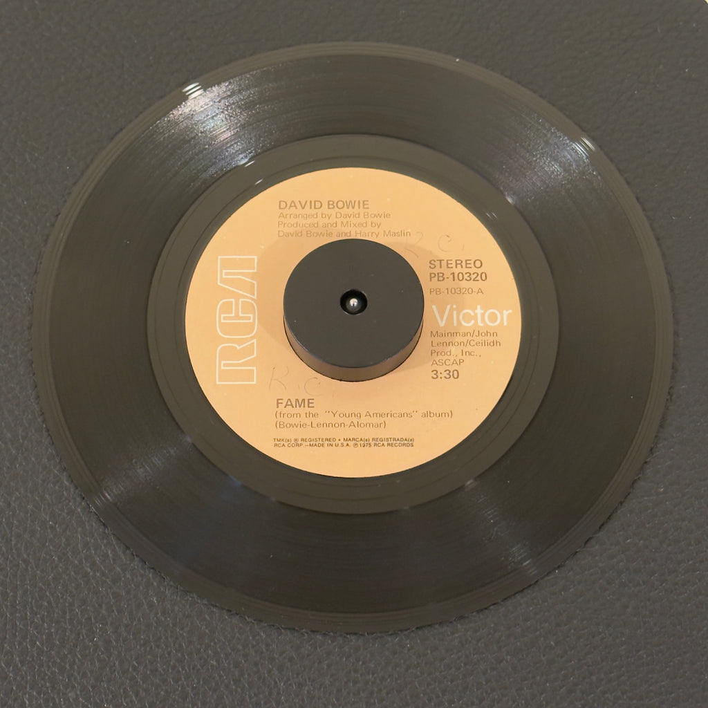 7" vinyl record by Bowie, David featuring "Fame/Right", released on RCA Victor (PB-10320), in VG+ (Very Good Plus) condition, classic analog collectable for turntable playback. Original RCA sleeve included. Writing on label Side A.
