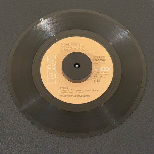 7" vinyl record by Bowie, David featuring "Fame/Right", released on RCA Victor (PB-10320), in VG+ (Very Good Plus) condition, classic analog collectable for turntable playback. Original RCA sleeve included. Writing on label Side A.