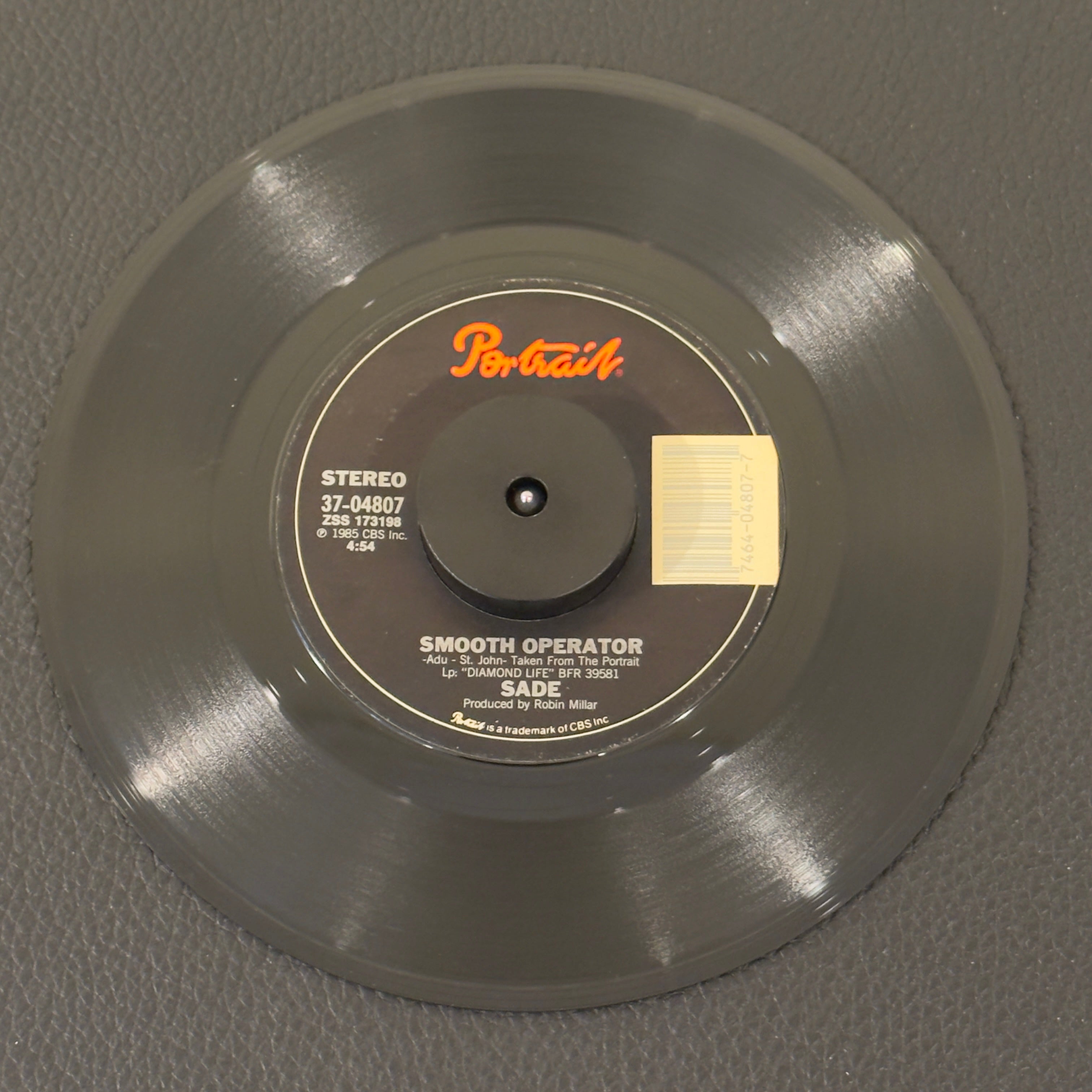 7" vinyl record by Sade featuring "Smooth Operator/Spirit", released on Portrait (37-04807), in VG (Very Good) condition, classic analog collectable for turntable playback. Pitman Pressing.  Does not inlcude Pic sleeve.