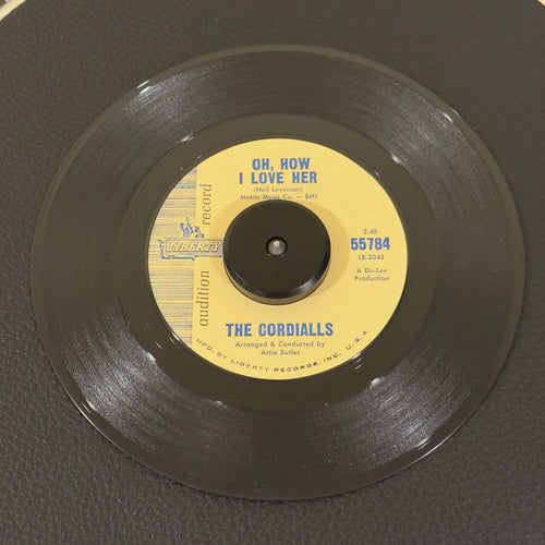 7" vinyl record by Cordialls, The featuring "Oh, How I Love Her/You Can't Believe In Love", released on Liberty (55784), in VG+ (Very Good Plus) condition, classic analog collectable for turntable playback. Audition Record of a mid-1960s harmony track bridging late doo-wop vocal structures with emerging Northern Soul/Pop-Rock styles. Writing on label (Side B).