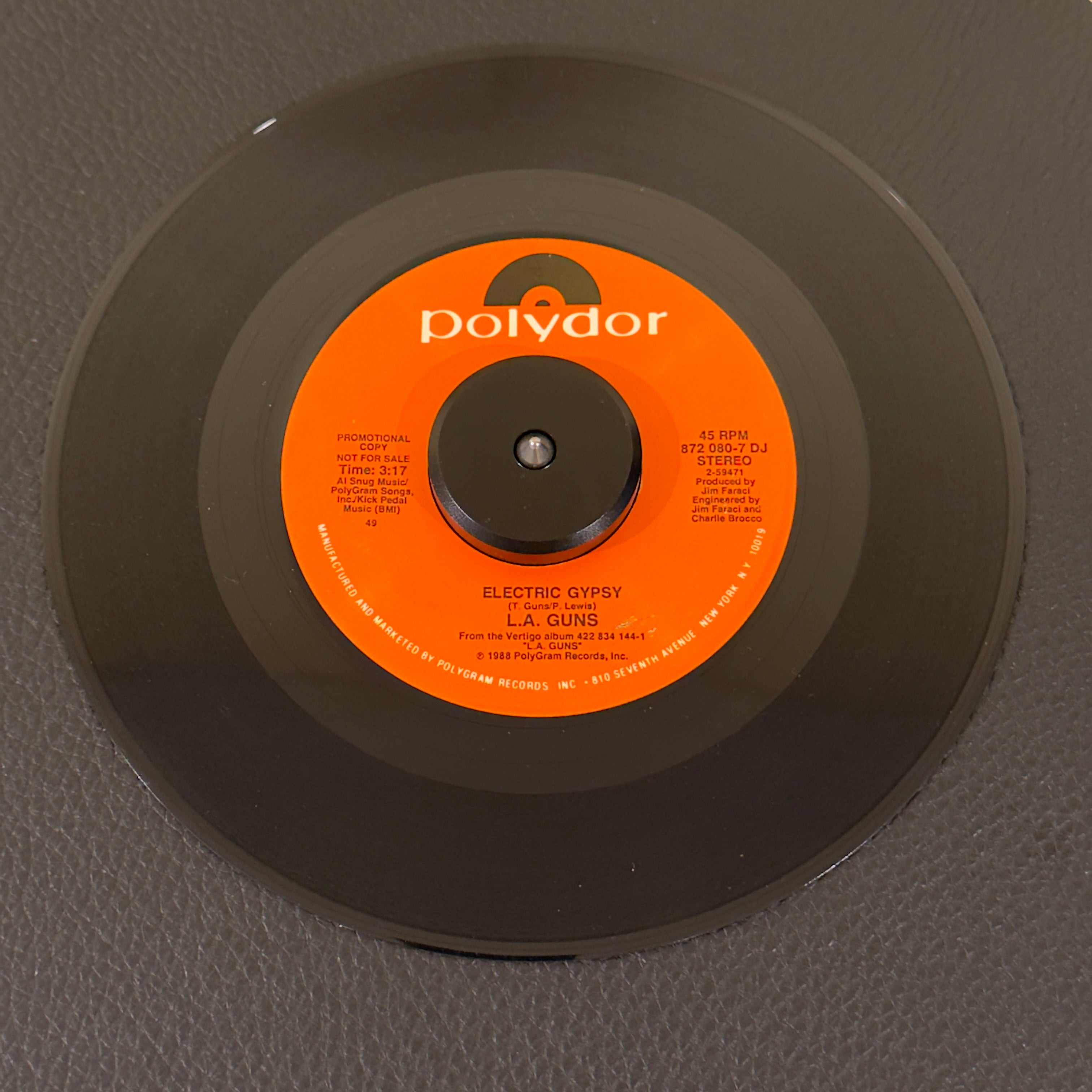 7" vinyl record by L.A. Guns featuring "Electric Gypsy/", released on Polydor (872-080-7 DJ), in NM (Near Mint) condition, classic analog collectable for turntable playback. Rare 1980's Hair Metal promo in original Polydor sleeve!!